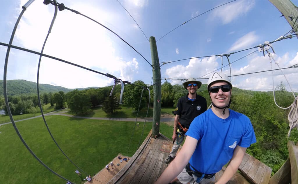 student standing at the top of the climbing tower